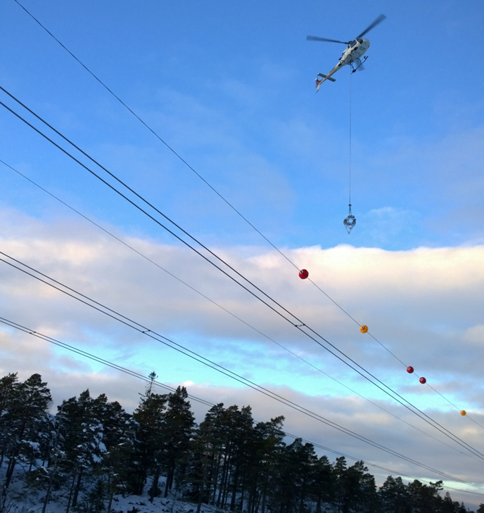 helicopter installing a air warming marker in a poweline