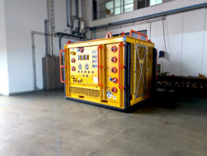 Yellow container rig, -Fluid sampling skid ready for inspection placed in a storage hall.