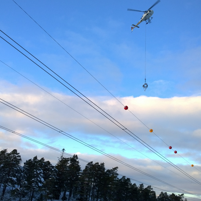 helicopter installing a air warming marker in a poweline