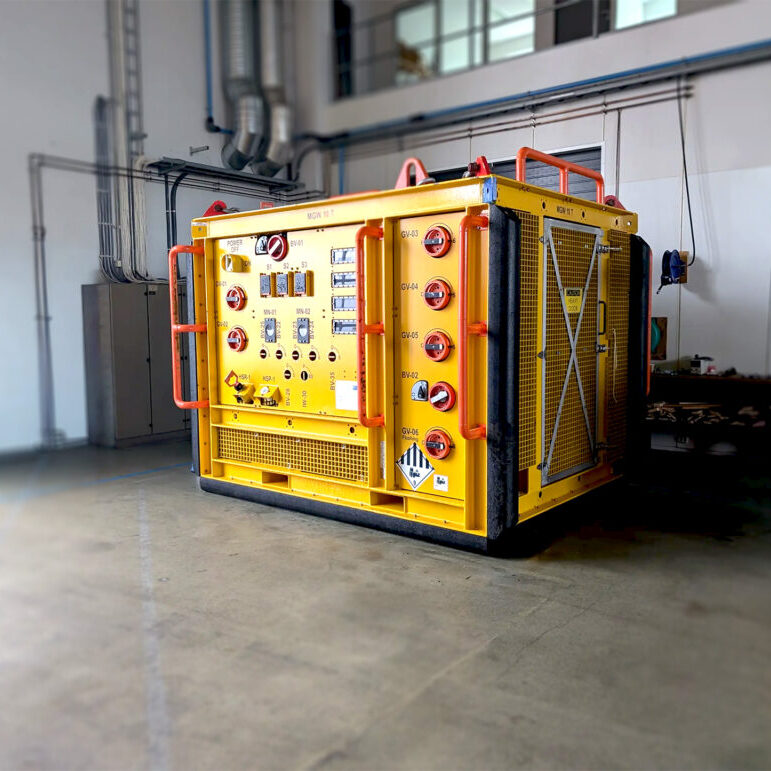Yellow container rig, -Fluid sampling skid ready for inspection placed in a storage hall.